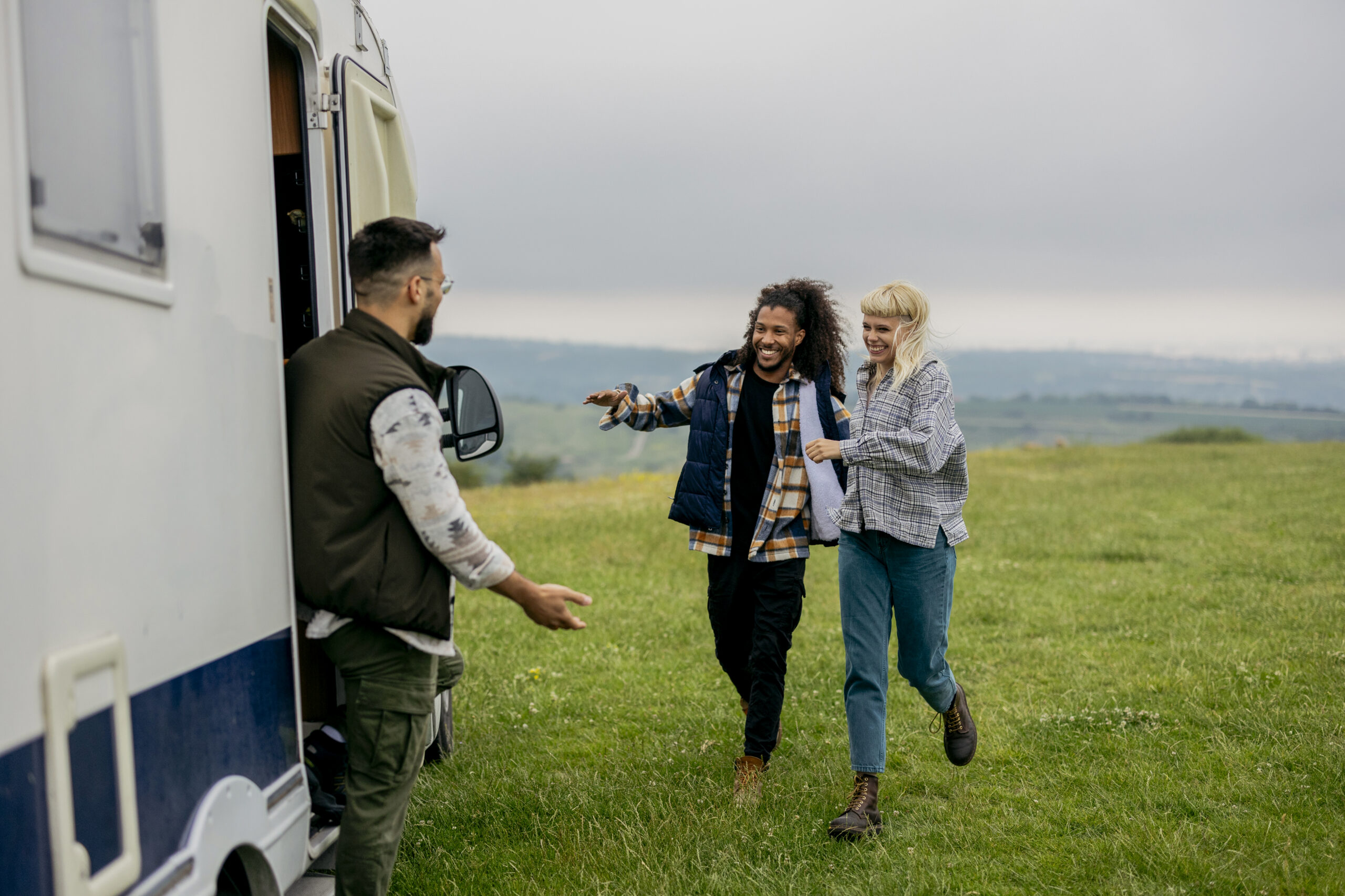 A Guide to the Ownership Costs of a Campervan Across the UK - Friends meeting in a field